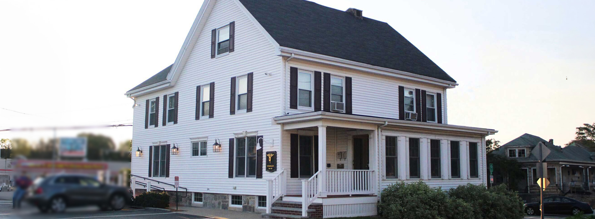 A two-story house with a prominent front porch and a shingled roof.