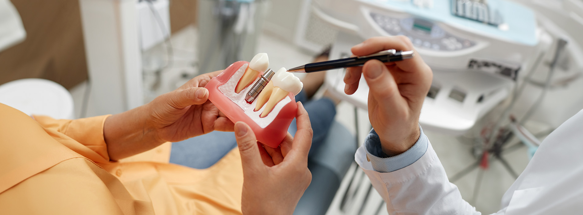 A person holding a toothbrush in their hand, with another person taking a photo of the toothbrush.