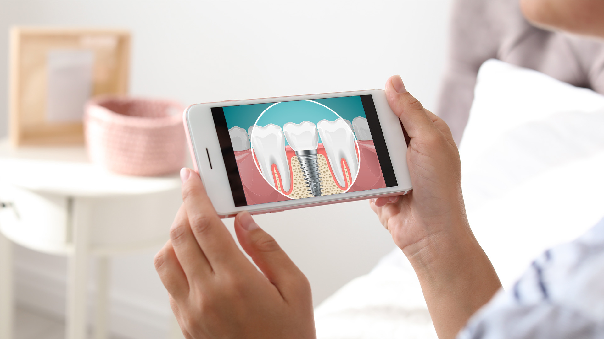 The image shows a person holding a smartphone displaying an image of a tooth with a magnified view of the gums, likely for dental health or educational purposes.