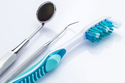 Dental instruments and toothbrushes on a white background.